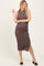 woman wearing a brown ribbed maternity midi dress with a side slit and showing her baby bump