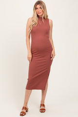 woman wearing a rust ribbed maternity midi dress with a side slit and a fitted silhouette, showing her baby bump