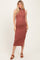 woman wearing a rust ribbed maternity midi dress with a side slit and a fitted silhouette, showing her baby bump