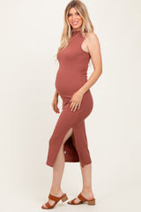 woman wearing a rust-colored ribbed maternity dress with side slits and a fitted silhouette, showing her baby bump