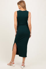 woman wearing a dark green ribbed maternity maxi dress with a side slit, showcasing her baby bump from the back