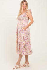 woman wearing a floral maternity dress with ruffle sleeves and pockets, showcasing her baby bump