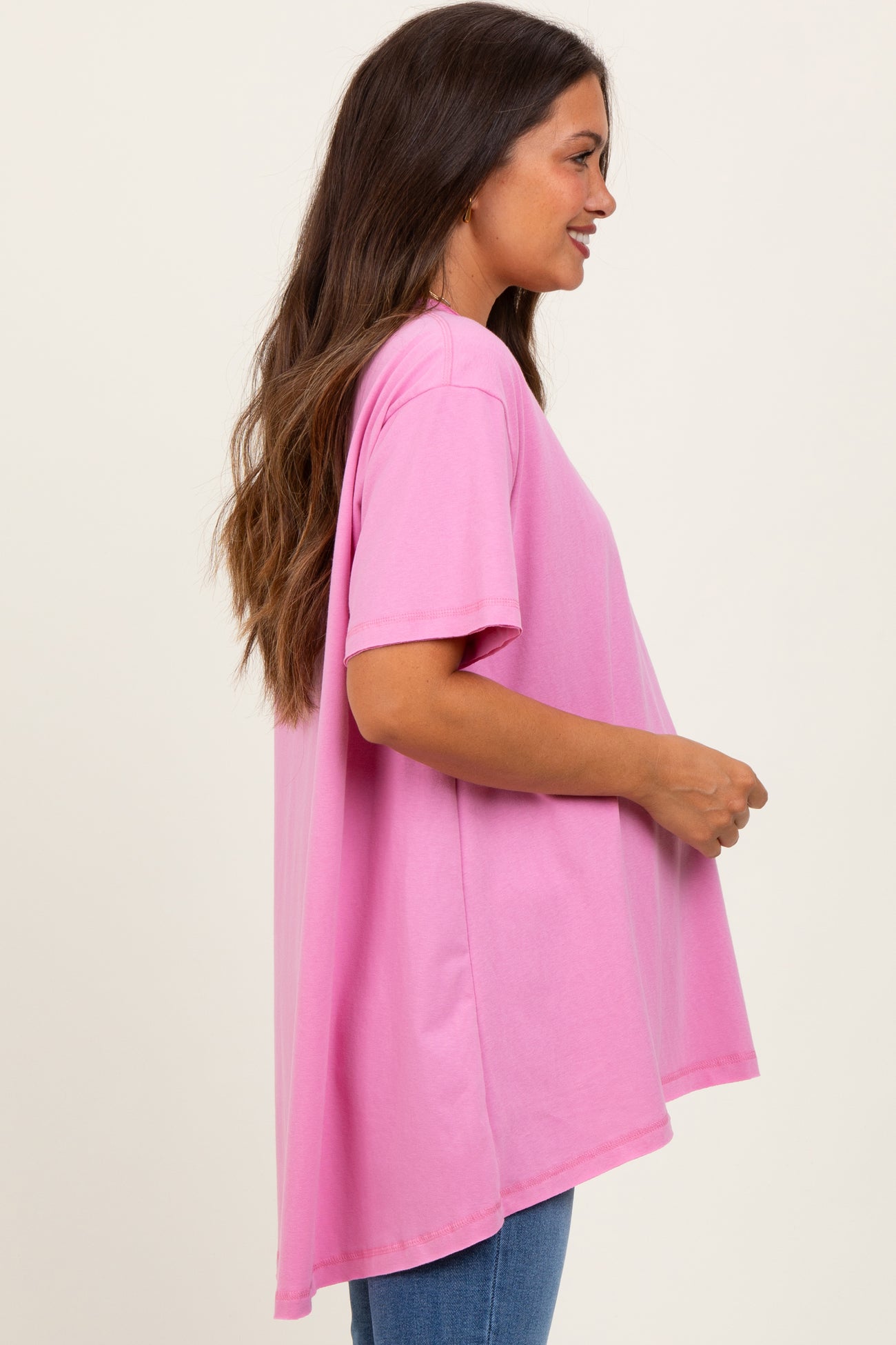 woman wearing a bright pink oversized maternity t-shirt with short sleeves and a relaxed fit
