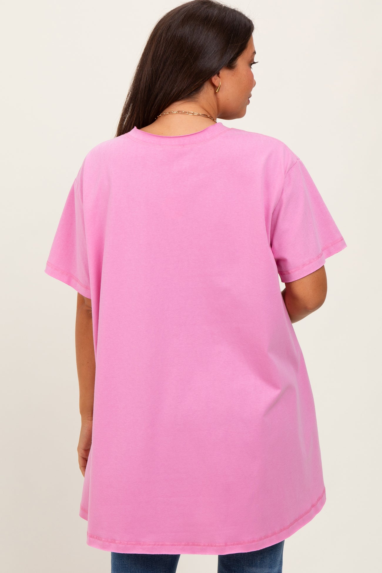 woman wearing a pink oversized maternity t-shirt with a relaxed fit and short sleeves