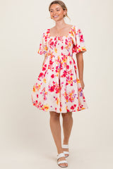 woman wearing a floral print short sleeve dress with a square neckline and a flowy skirt