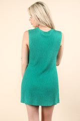 woman wearing a green sleeveless knit dress showing a ribbed texture from the back