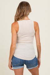 woman wearing a light beige maternity tank top and denim shorts, showing the back view