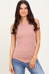 woman wearing a light pink sleeveless ribbed top with a high neckline and blue jeans
