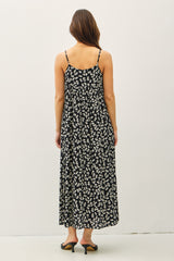 woman wearing a black floral maxi dress with spaghetti straps, seen from the back