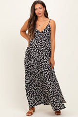 woman wearing a black floral maternity maxi dress with spaghetti straps and a flowy silhouette