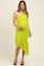 woman wearing a bright green one-shoulder maternity dress with a ruched design and asymmetrical ruffle hem, showing baby bump