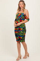 woman wearing a tropical print off-the-shoulder bodycon dress with ruching, standing against a neutral background
