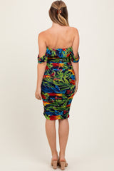 woman wearing a colorful tropical print off-the-shoulder bodycon dress with ruched details