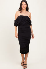 woman wearing a black off-shoulder bodycon dress with ruched detailing and mid-length hemline