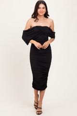 woman wearing a black off-shoulder fitted midi dress with ruched detailing