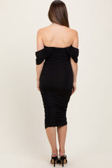 woman wearing a black off-the-shoulder maternity dress with ruching and a fitted silhouette