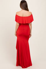 woman wearing a red off-the-shoulder maternity gown with a fitted bodice and flared skirt, showing a baby bump from the back
