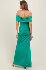 woman wearing a green off-shoulder maxi dress with gathered detailing at the back