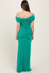 woman wearing a green off-the-shoulder maternity gown with ruching details, showing the back view