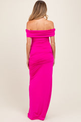 woman wearing a pink off-the-shoulder maternity maxi dress showcasing a fitted silhouette and ruched detailing