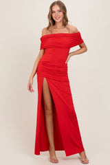 woman wearing a red off-the-shoulder maxi dress with ruching and a high slit