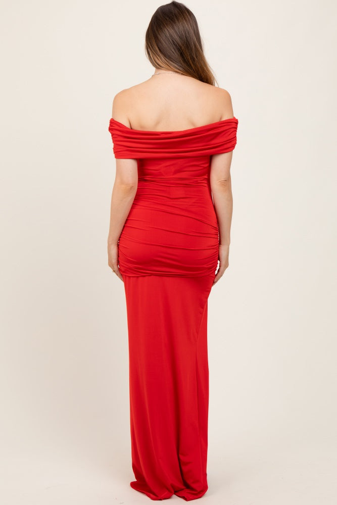 woman wearing a red off-the-shoulder maternity dress with ruched detailing and a fitted silhouette