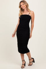 woman wearing a black ruched midi dress with spaghetti straps and a fitted silhouette