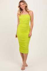woman wearing a bright lime green ruched midi dress with a strapless design and a fitted silhouette