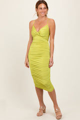 woman wearing a bright lime green ruched midi dress with spaghetti straps and a v-neckline