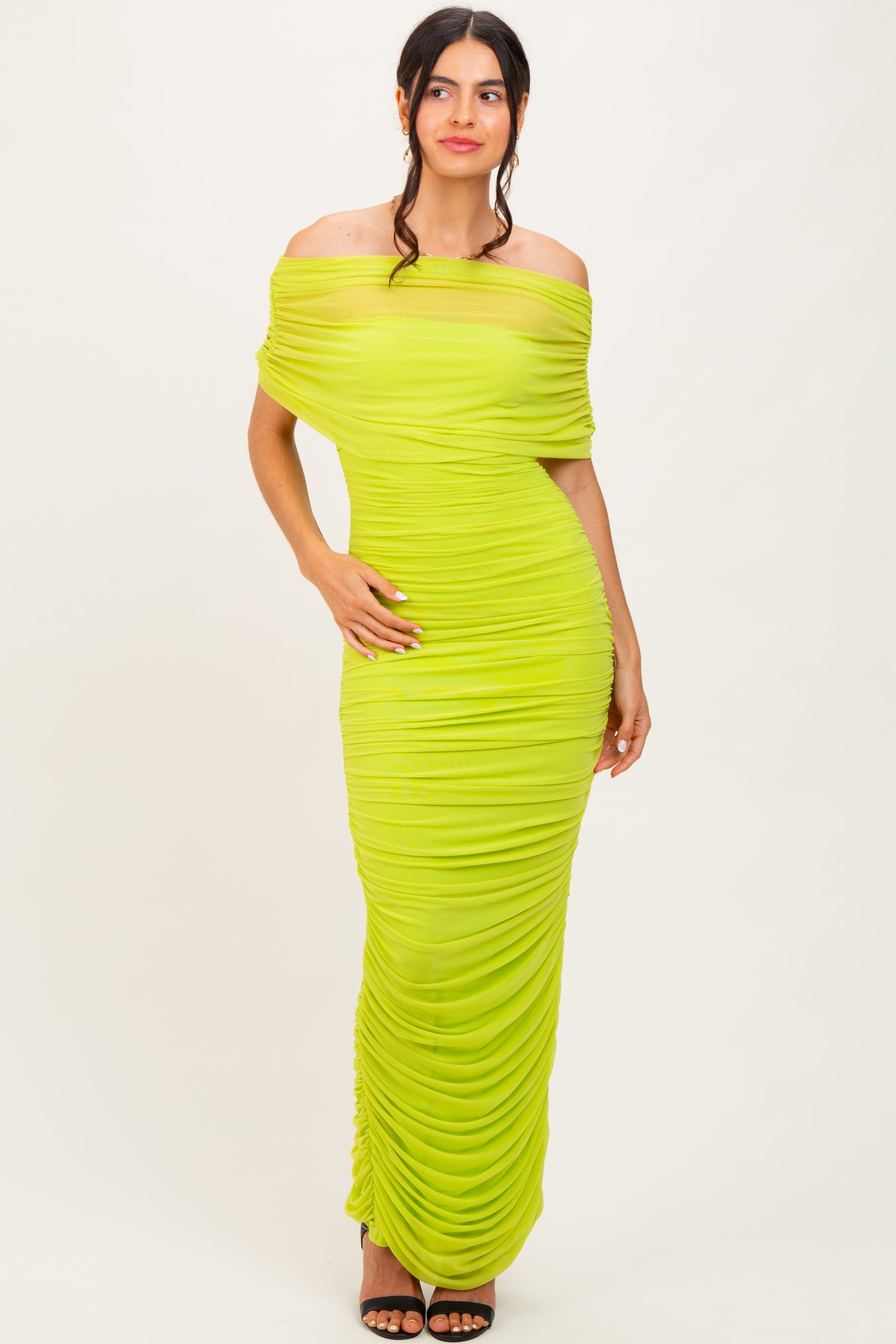 woman wearing a bright lime green off-the-shoulder ruched maxi dress with a fitted silhouette