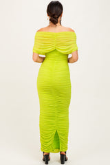woman wearing a lime green off-shoulder ruched maxi dress with a slit at the back