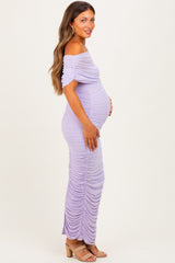 woman wearing a lilac off-shoulder maternity dress with ruching and holding her baby bump