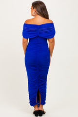 woman wearing a blue off-the-shoulder ruched maternity gown with a slit at the back