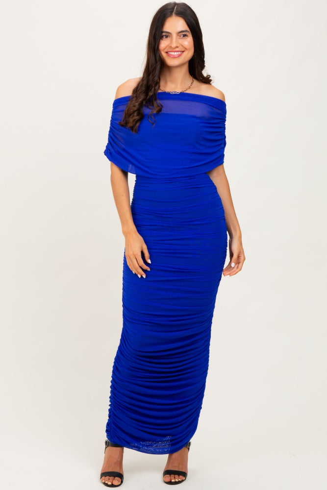woman wearing a royal blue off-the-shoulder ruched maxi dress with a fitted silhouette and strappy heels