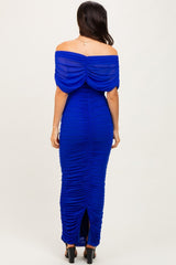 woman wearing a royal blue off-the-shoulder fitted evening gown with ruched details and a back slit