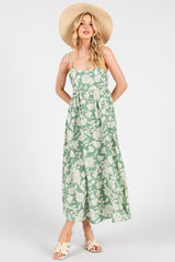 woman wearing a green floral maxi dress with spaghetti straps and a wide-brimmed hat