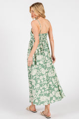 woman wearing a green floral maxi dress with a smocked back and adjustable straps