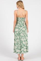 woman wearing a green floral maxi dress with a smocked back and thin straps, shown from the back