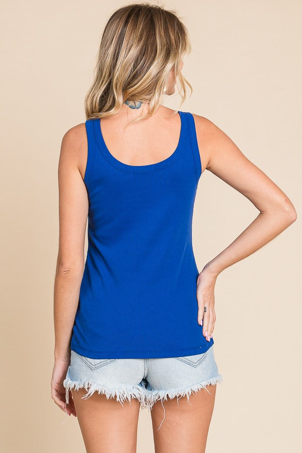 woman wearing a royal blue ribbed tank top and light wash distressed denim shorts, viewed from the back