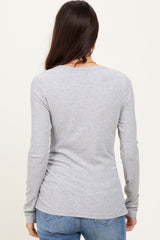 woman wearing a fitted gray long sleeve top viewed from the back, paired with blue jeans