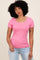 woman wearing a pink short sleeve ribbed top with a scoop neckline and light blue jeans
