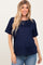 woman wearing a navy blue short sleeve maternity top and showing her baby bump