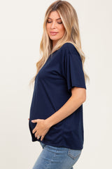 woman wearing a navy blue short sleeve maternity top and holding her baby bump