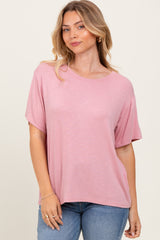woman wearing a pink short sleeve relaxed fit top and blue jeans
