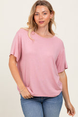 woman wearing a soft pink short sleeve top with a relaxed fit and round neckline, paired with light blue jeans