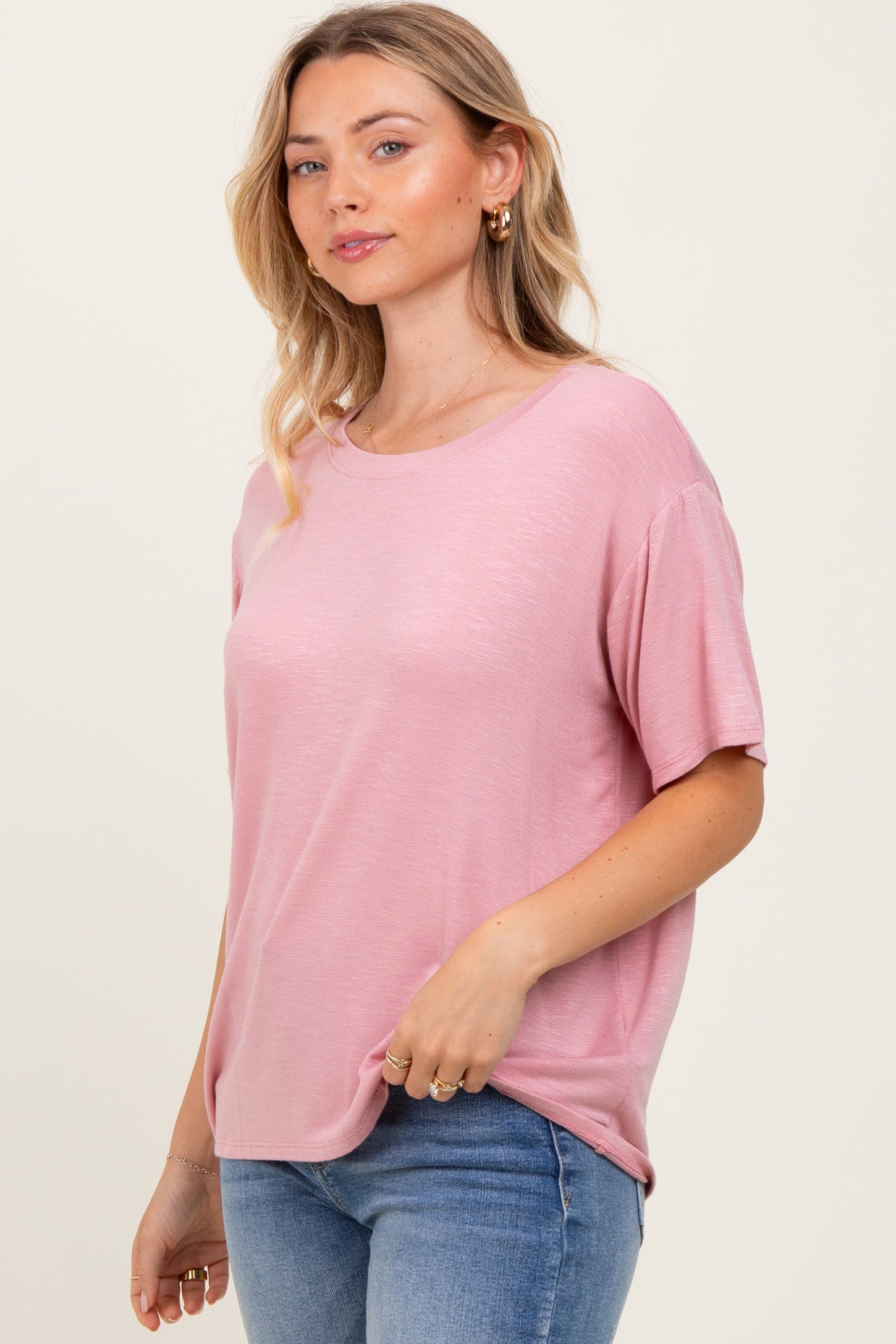woman wearing a soft pink short sleeve t-shirt paired with light blue jeans