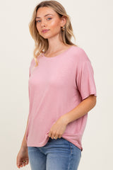 woman wearing a soft pink short sleeve t-shirt paired with light blue jeans