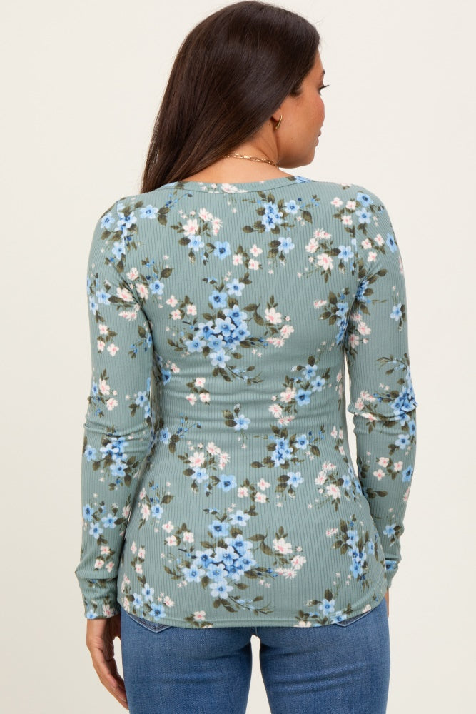 woman wearing a floral long sleeve maternity top in green with a fitted style, showing the back view