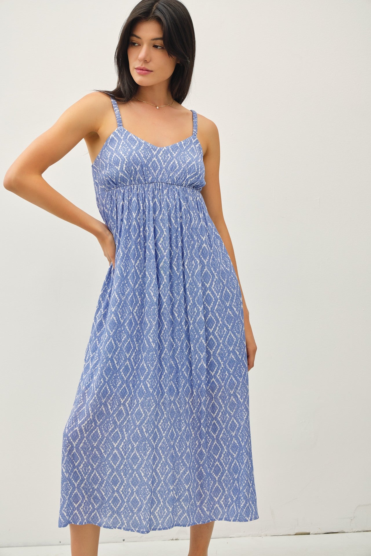 woman wearing a blue patterned maxi dress with adjustable straps and a gathered bodice