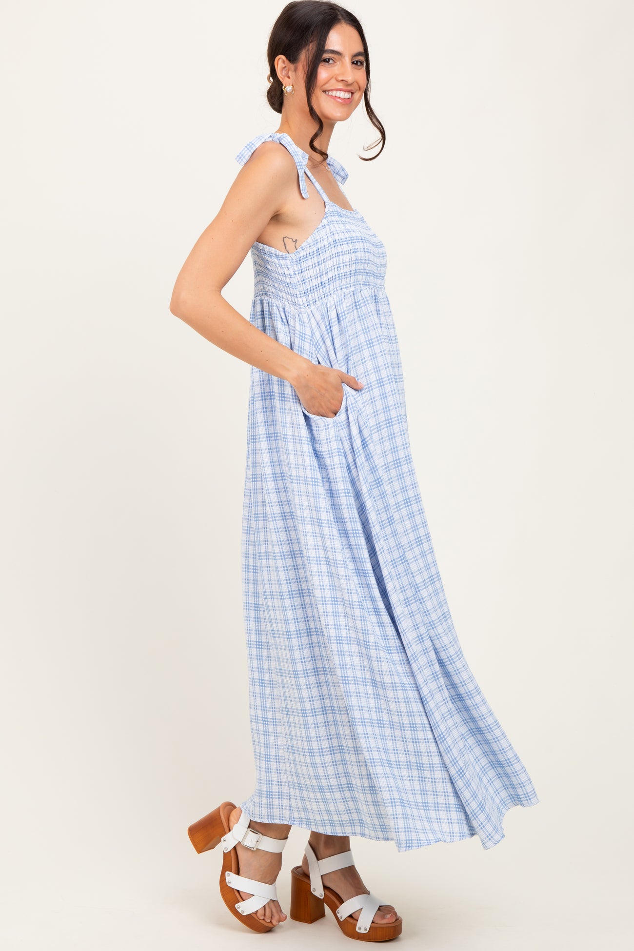 woman wearing a blue and white plaid maxi dress with a smocked bodice and pockets